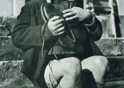 Werfel de apenas 6 anos, austríaco e órfão, abraça seu mais novo par de sapatos.