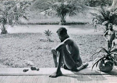 Pai olha para a mão e o pé de sua filha de 5 anos, cortados como uma punição por não ter cumprido a cota diária de extração de borracha. Congo, 1904.
