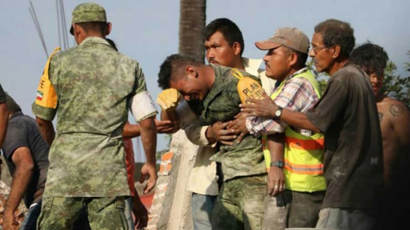 Soldado se desespera ao não conseguir resgatar mãe e filha com vida dos escombros de um edifício em Morelia, México, após o terremoto de 19 de setembro de 2017.